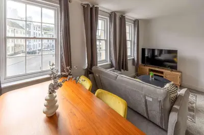 a living room with a table and a couch at Bright 1 Bed Harbour-side Apartment with Sea Views in Whitehaven