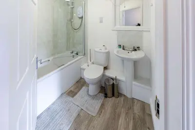 a white bathroom with a toilet and a sink at Bright 1 Bed Harbour-side Apartment with Sea Views in Whitehaven