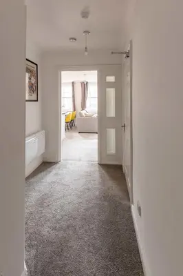 a white room with a hallway with a living room at Bright 1 Bed Harbour-side Apartment with Sea Views in Whitehaven
