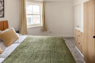 a bedroom with a large bed and a window at Bright 1 Bed Harbour-side Apartment with Sea Views in Whitehaven