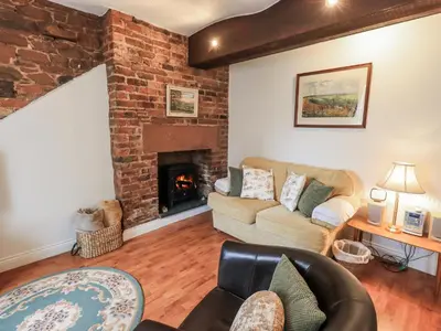 a living room with a couch and a fireplace at The Coach House in Wigton