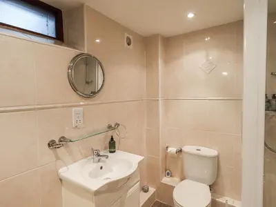 a bathroom with a toilet and a sink and a mirror at The Coach House in Wigton