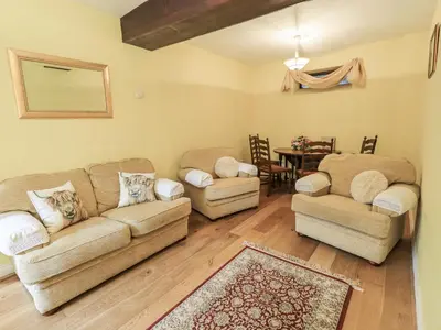 a living room with two couches and a table at Millers Cottage in Wigton