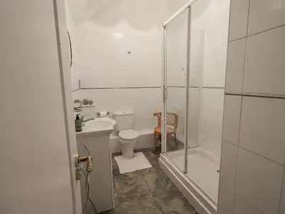 a bathroom with a shower and a toilet and a sink at Millers Cottage in Wigton