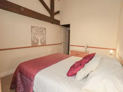 a bedroom with a bed with a red pillow on it at The Hayloft in Wigton