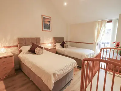 a bedroom with two beds and a window at The Hayloft in Wigton