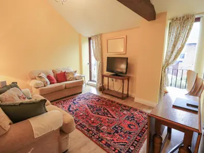 a living room with a couch and a tv at The Hayloft in Wigton