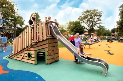 a group of people on a slide at a playground at Modern Two-Bedroom Apartment Near River with Free Parking & WiFi in Dumfries