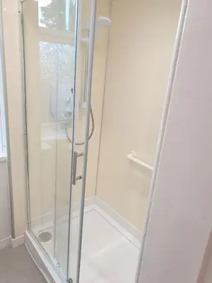 a shower with a glass door in a bathroom at Modern Two-Bedroom Apartment Near River with Free Parking & WiFi in Dumfries