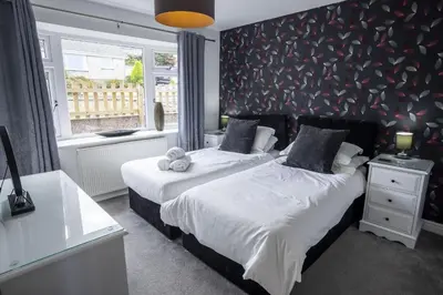 a bedroom with two beds and a wall with hearts at Fellside Hideaway in Keswick