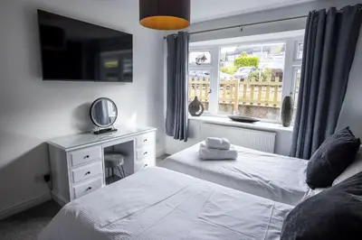 a bedroom with two beds and a window at Fellside Hideaway in Keswick