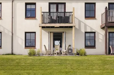 a house with two chairs and a balcony at The Hide - Ridgestone in Penrith