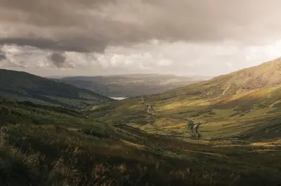 a view of a valley with a road in the mountains at The Hide - Ridgestone in Penrith