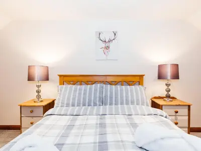 a bedroom with a bed with two night stands at The Barn in Girthon