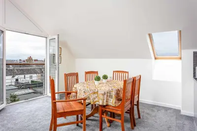 a dining room with a table and chairs and a window at The Portland Penthouse - Donnini Apartments in Troon