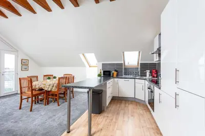 a kitchen and dining room with a table and chairs at The Portland Penthouse - Donnini Apartments in Troon