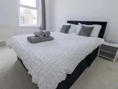 a bedroom with a large bed with towels on it at Cumberland House in Workington