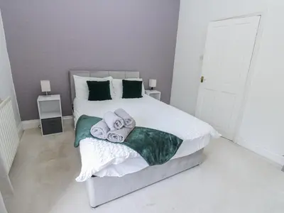 a bedroom with a bed with towels on it at Cumberland House in Workington