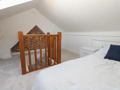 a bedroom with a white bed and a staircase at Lonsdale Street in Workington