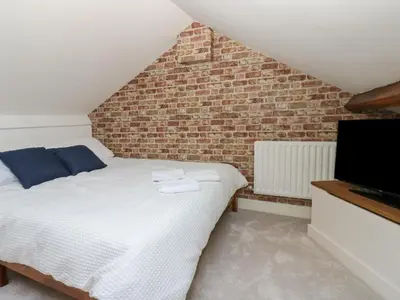 a bedroom with a bed and a brick wall at Lonsdale Street in Workington