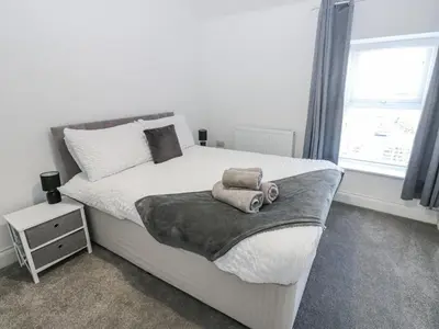 a bedroom with a large white bed with towels on it at Keekle Terrace in Cleator Moor