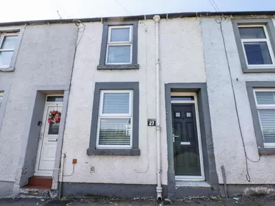 a white building with windows and a door at Keekle Terrace in Cleator Moor