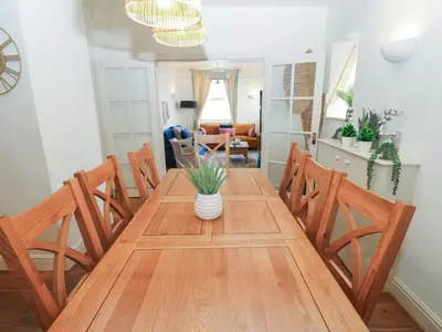 a dining room table with chairs and a vase on it at Hampton House in St Bees