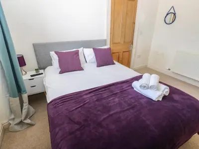 a bedroom with a large bed with towels on it at Hampton House in St Bees