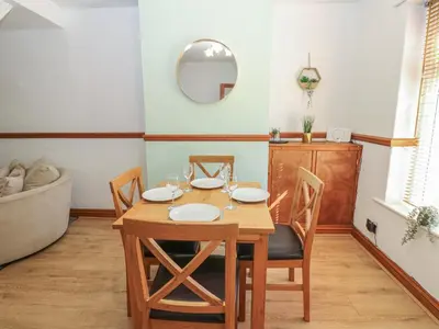a dining room with a table and chairs and a tub at Bolton Terrace in Workington