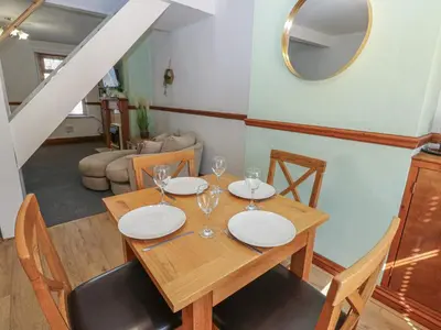 a dining room with a wooden table and chairs at Bolton Terrace in Workington
