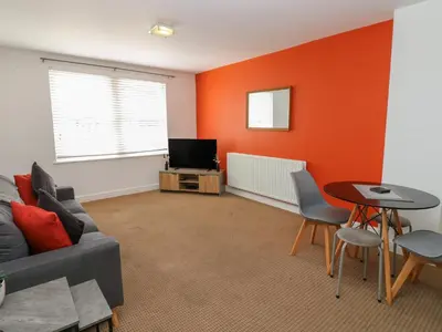 a living room with a couch and a tv at Curwen Apartment in Workington