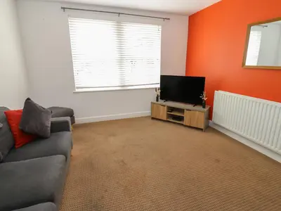 a living room with a couch and a flat screen tv at Curwen Apartment in Workington