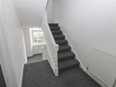 a staircase in a white room with a window at Georgian Town House in Whitehaven