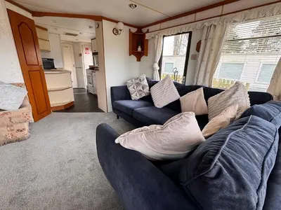 a living room with a blue couch with pillows at No 26 Mountain View in Cockermouth