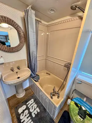 a small bathroom with a sink and a tub and a sink at No 26 Mountain View in Cockermouth
