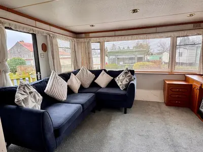 a living room with a blue couch with pillows at No 26 Mountain View in Cockermouth