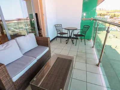 a couch on a balcony with a table and chairs at Pears Suite in Whitehaven