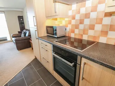 a kitchen with a stove and a microwave at Pears Suite in Whitehaven