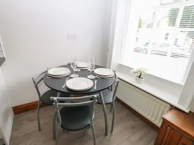 a dining room with a table and chairs and a window at Kirkgate Cottage in Cockermouth