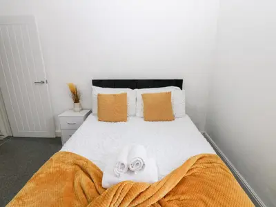 a bedroom with a bed with towels on it at Holly House in Whitehaven