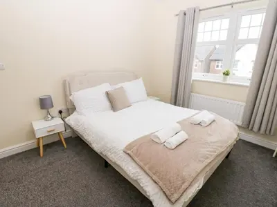 a bedroom with a bed with towels on it at Lingla House in Frizington