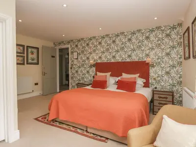a bedroom with a bed with a orange bedspread at Shelley in Ambleside