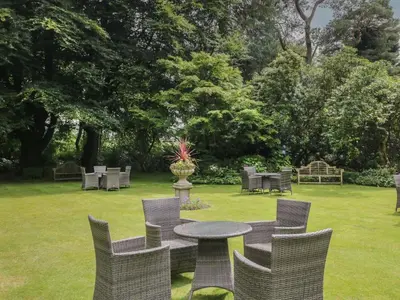 a table and chairs in a yard with a grass field at Shelley in Ambleside