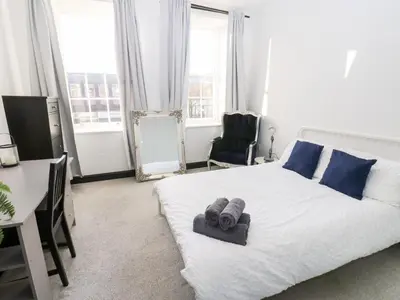 a bedroom with a bed and a desk and a chair at Lowther Apartment in Whitehaven