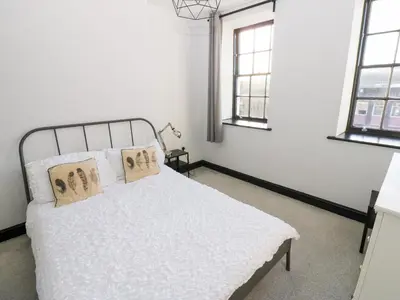 a bedroom with a white bed with two pillows at Lowther Penthouse in Whitehaven