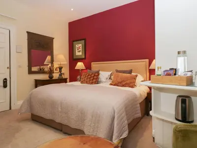 a bedroom with a large bed with a red wall at Dorothy in Ambleside