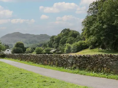 a stone wall next to a road at Dorothy in Ambleside