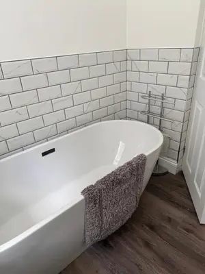a white bath tub in a bathroom with white tiles at Lower Milntown Farm in Ramsey