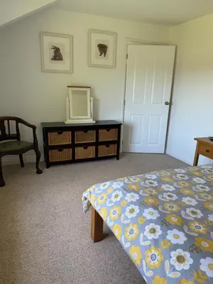 a bedroom with a bed and a dresser and a mirror at Lower Milntown Farm in Ramsey