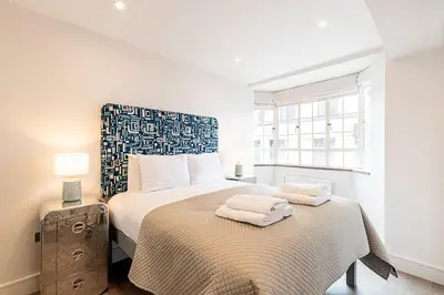 a bedroom with a bed with two towels on it at Stylish Chelsea Flat Near Sloane Square in Moffat